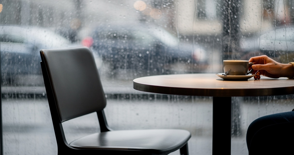Person sitting alone at a rainy cafe window, reflecting on healing after a toxic relationship
